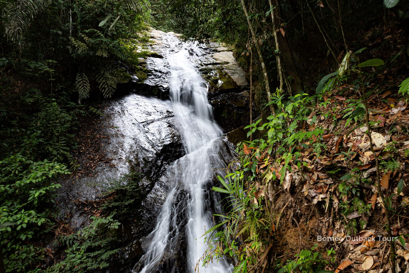 A silky waterfall cascading through mossy boulders in the Sapulot rainforest, Sabah