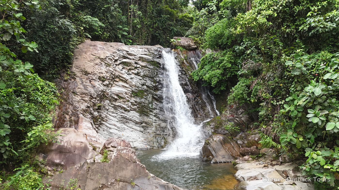 Aerial view of Kabulongou Waterfall and its plunge pool surrounded by rainforest, Sapulot, Sabah