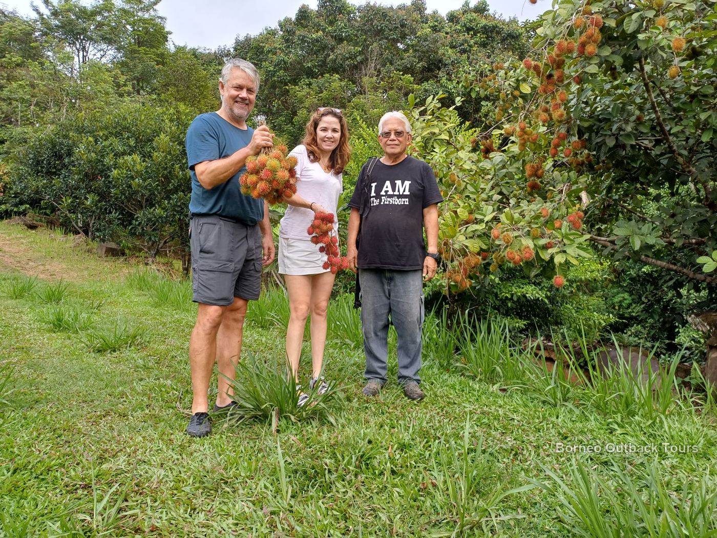 Dr. Richard Gunting and guests holding freshly picked rambutan at MunorAulai farm, Sapulot