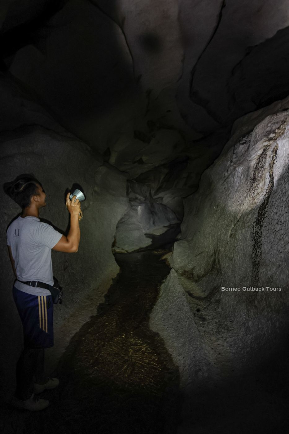 A guide holding a torch inside Pungiton Cave, a sacred site of the Murut people in Sapulot, Sabah