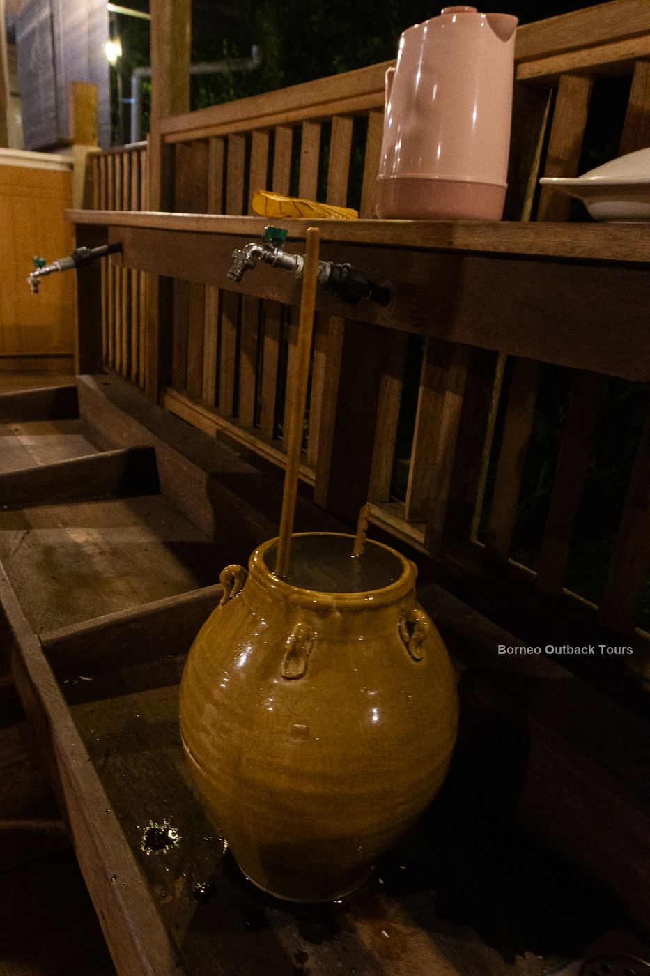 A traditional glazed tapai jar with a long bamboo drinking straw in a Murut longhouse in Sapulot, Sabah