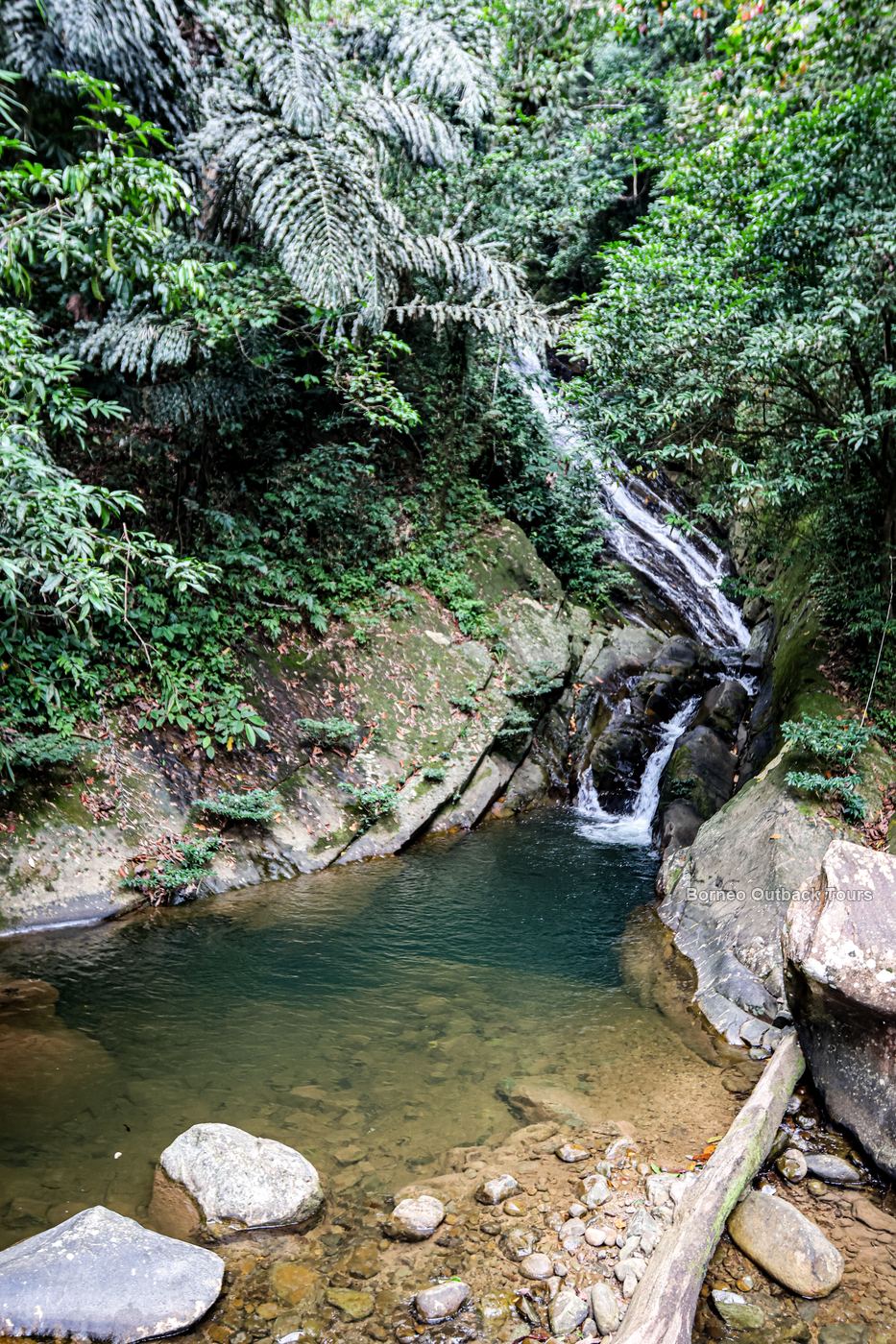 A jungle waterfall falling into an emerald plunge pool near Sapulot, Sabah